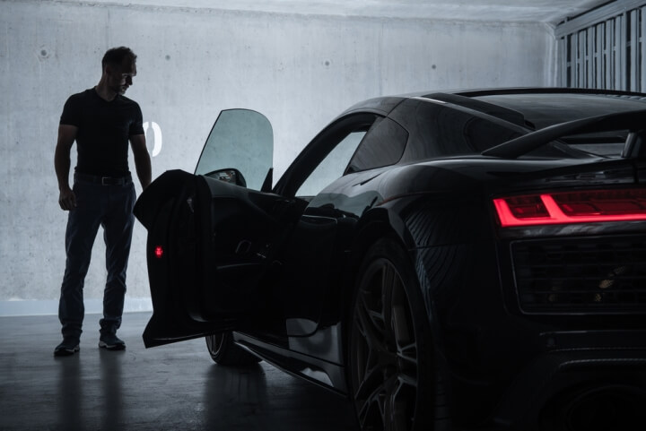 Man in the garage looking at his exotic car. Exotic car transport.