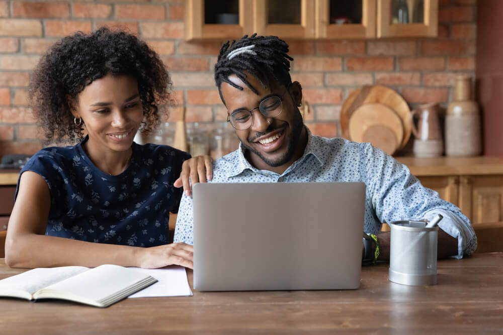 A couple checks reviews on their laptop.
