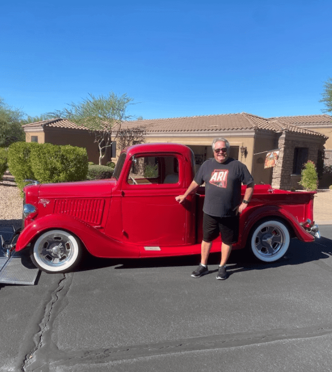 A happy customer is standing next to his classic pickup truck. Classic car transport is what we do best.