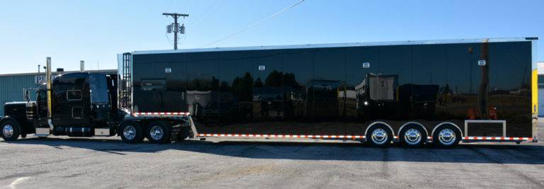 An all-black six-car enclosed auto transport trailer.