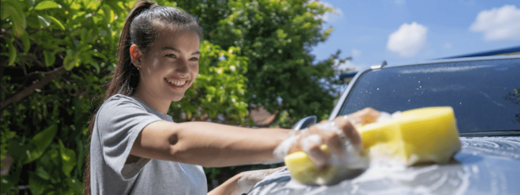 A woman is smiling while washing her car. Before you ship a car, clean it inside and out. It is standard auto transport industry practice to request that you wash your vehicle.